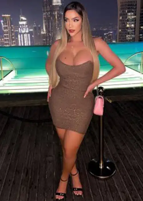 Sizzling thick stripper shows her curves before a city backdrop.