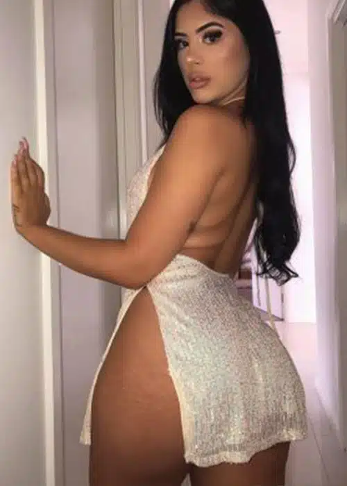 Stunning woman gives you a look at her curves in a white sequin outfit.